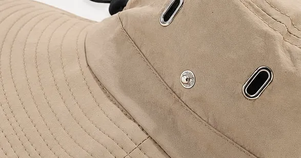Close-up of the metal eyelets and snap on the crown of the khaki bucket hat